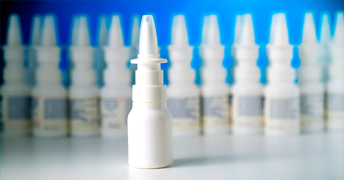 Nasal spray bottle resembling Epinephrine with multiple nasal spray medication bottles in background.